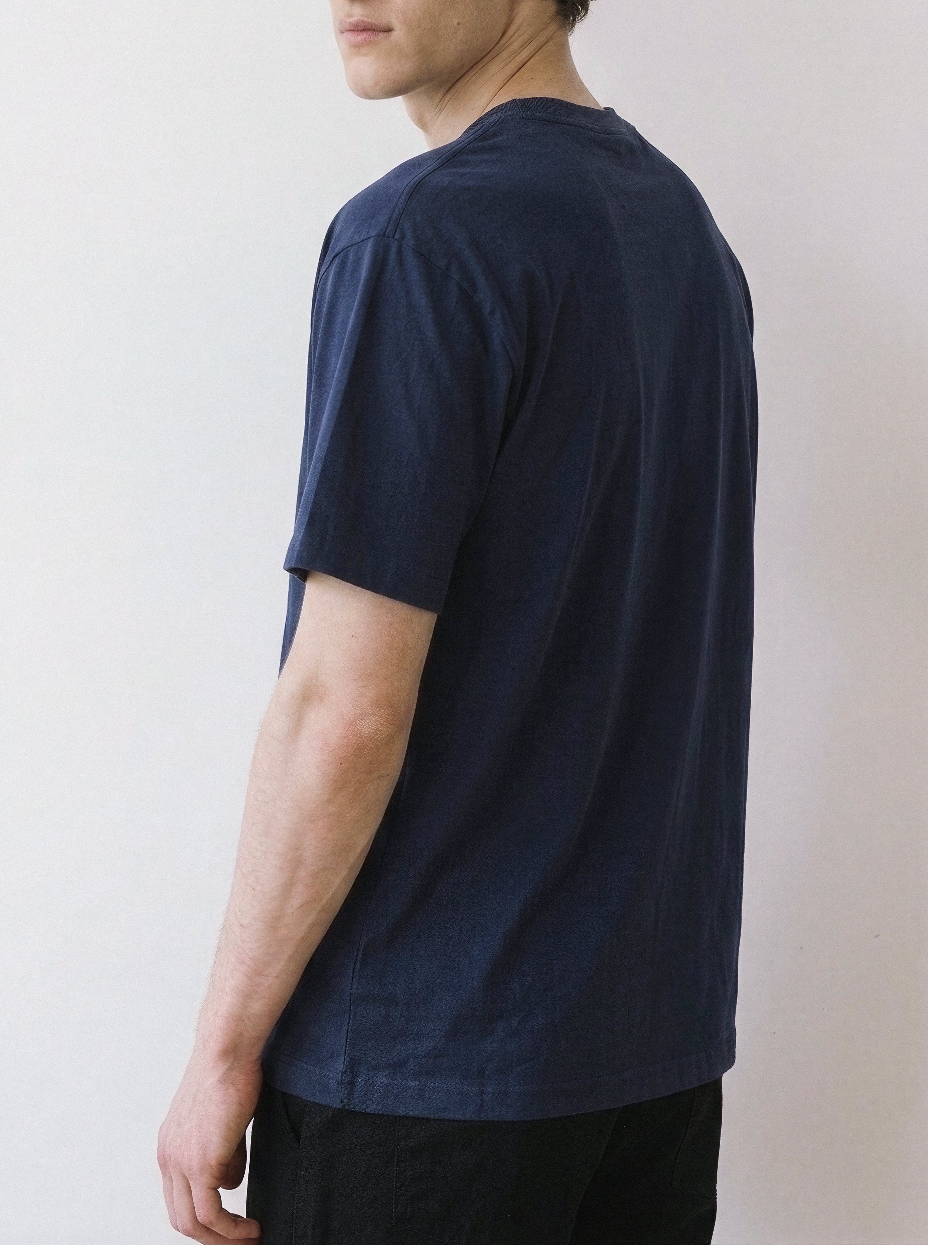 Back and side angle view of a model, showing the comfortable fit of a vintage navy oversized t-shirt featuring a continuous line drawing.