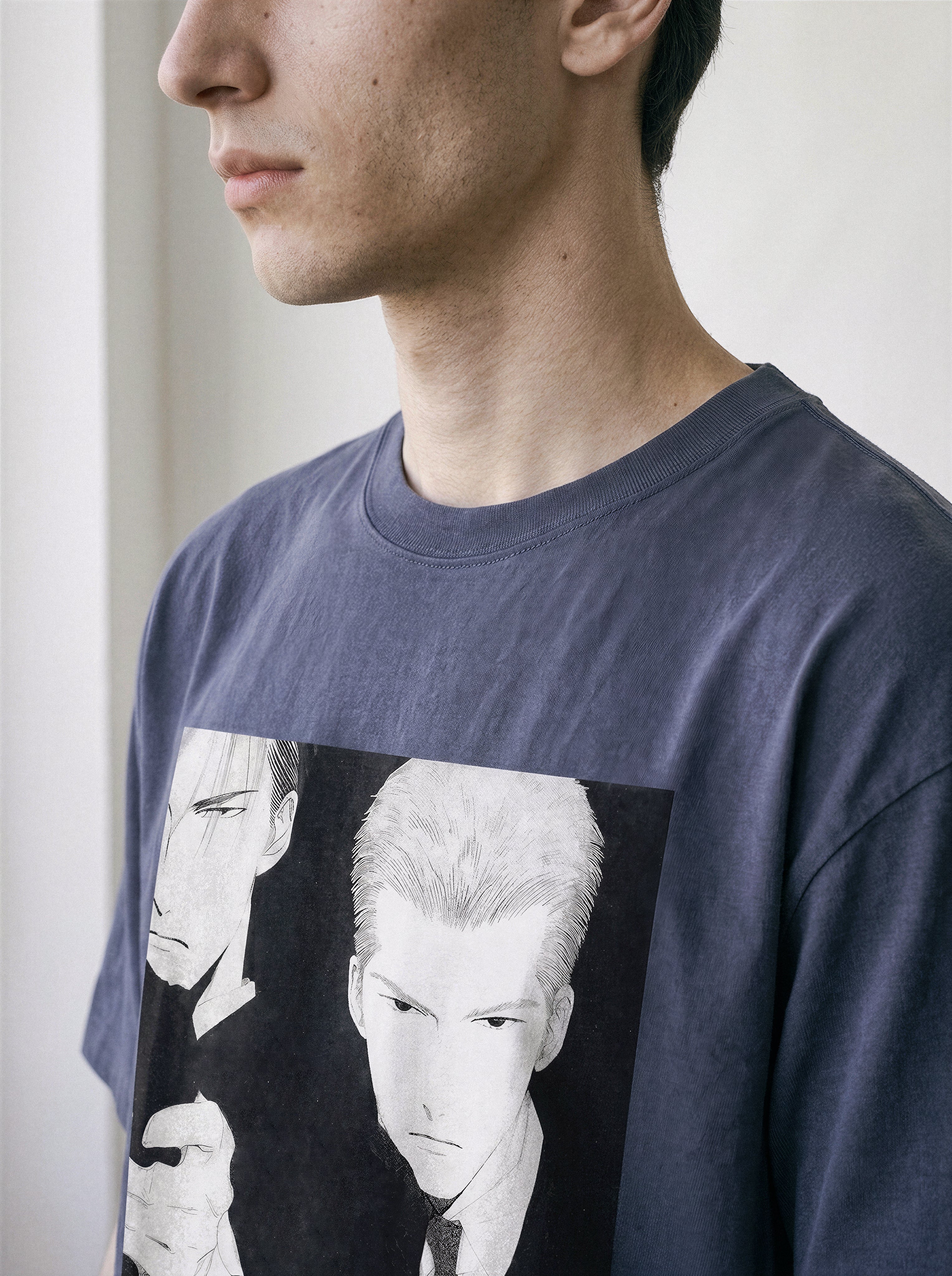 Side profile of a model wearing a vintage navy oversized t-shirt, emphasizing the fit and the striking black and white retro manga Yakuza illustration.