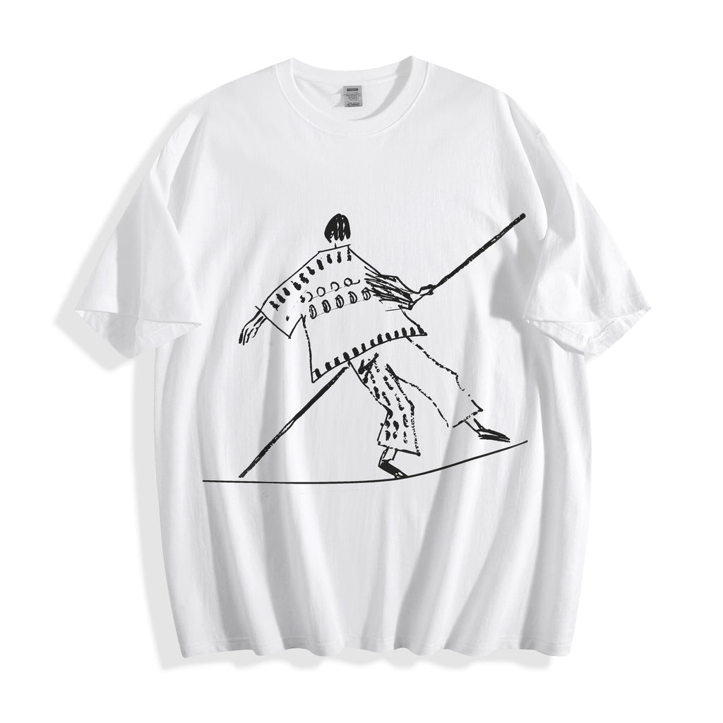 Clean flat lay product shot of a white oversized t-shirt featuring a high-contrast black tightrope walker line art design.