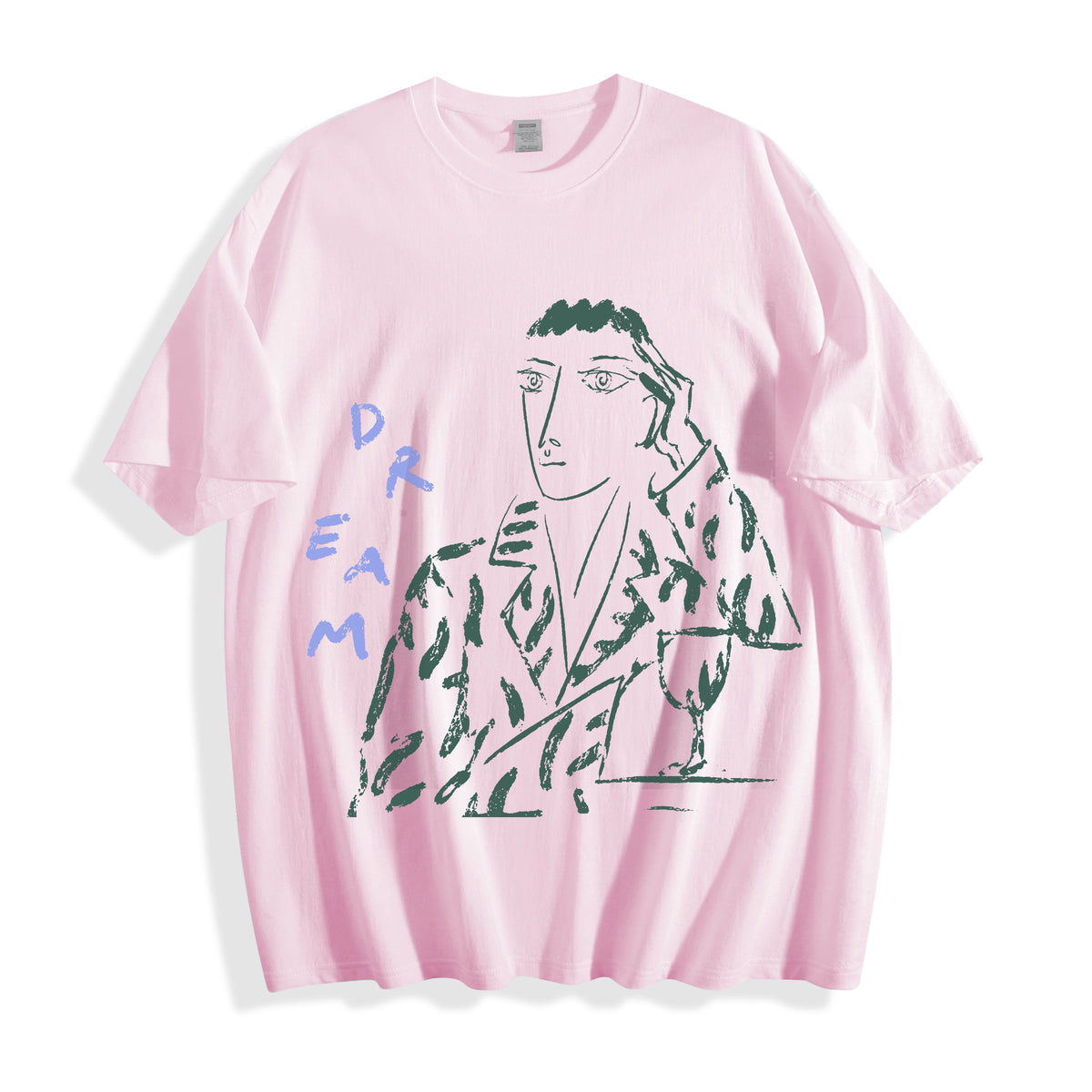 A flat lay of a light pink hand-lettered dream portrait line art graphic tee, blending soft pastel tones with a striking pure line art form.